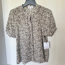 Load image into Gallery viewer, Patterned blouse on a hanger with a visible brand tag against a white background