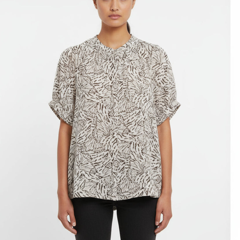 Zebra print blouse on a hanger with a visible brand tag against a white background