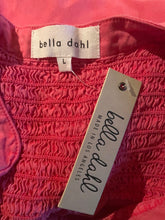 Load image into Gallery viewer, Close-up of a red textured fabric with 'bella dahl' brand labels on it.