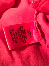 Load image into Gallery viewer, Close-up of a label on a red fabric item with text and numbers.