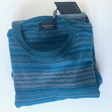Load image into Gallery viewer, Folded blue sweater with a brand tag on a white background
