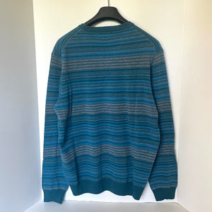 Blue striped sweater on a hanger against a white background