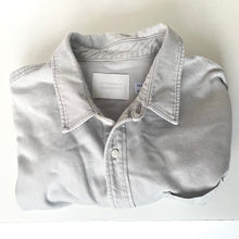 Load image into Gallery viewer, Folded light gray shirt with a visible brand label on a white background