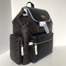 Load image into Gallery viewer, Coach backpack with floral pattern and black accents on a white background