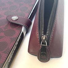 Load image into Gallery viewer, Close-up of a maroon leather wallet with a zipper on a light background