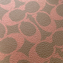 Load image into Gallery viewer, Close-up of a textured fabric with a circular pattern in brown and pink.