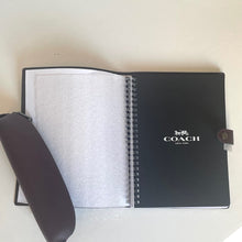 Load image into Gallery viewer, Coach notebook with a pen holder on a light background