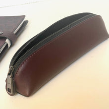 Load image into Gallery viewer, Brown leather pencil case with a zipper on a light beige background