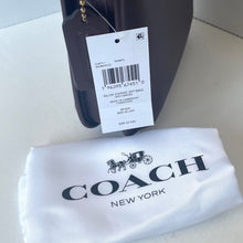 Load image into Gallery viewer, Coach handbag with a tag and white dust bag on a light background
