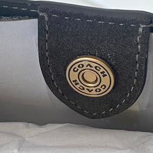 Load image into Gallery viewer, Close-up of a Coach logo on a black leather patch.