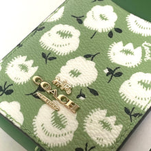 Load image into Gallery viewer, Green wallet with white floral pattern and gold Coach logo