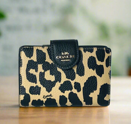 Leopard print wallet with Coach logo on a white background