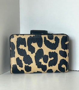 Leopard print wallet on a white surface with a white wall background