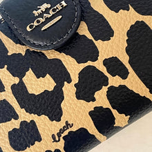 Load image into Gallery viewer, Close-up of a Coach wallet with leopard print pattern and visible brand logo.