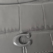 Load image into Gallery viewer, Close-up of a gray textured surface with a metallic 'C' logo.