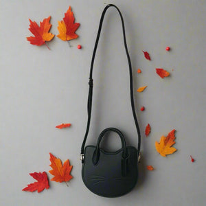 Black handbag with a long strap on a white background