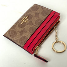 Load image into Gallery viewer, Brown wallet with red interior and gold keychain on a white background