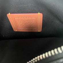 Load image into Gallery viewer, Coach label on a black leather product with visible stitching