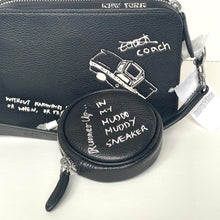 Load image into Gallery viewer, Black Coach bag with a round pouch featuring text on a white background
