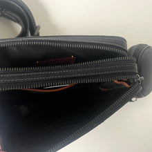 Load image into Gallery viewer, Close-up of a black bag with zippers on a light background