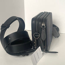 Load image into Gallery viewer, Black leather bag with a strap and Coach tag on a white background