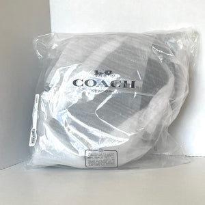 Coach headrest cover in clear packaging on a white background