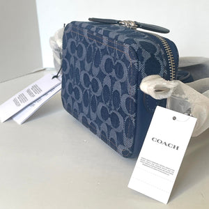 Blue Coach handbag with a tag on a light gray background