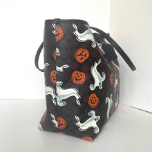 Load image into Gallery viewer, Black bag with Halloween-themed design featuring ghosts, pumpkins, and dogs on a white background.