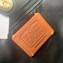 Load image into Gallery viewer, Brown leather tag with embossed text on a dark textured surface
