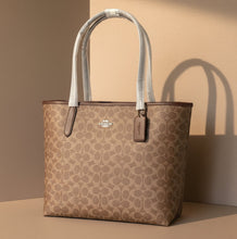 Load image into Gallery viewer, Coach tote bag with a white interior on a white background