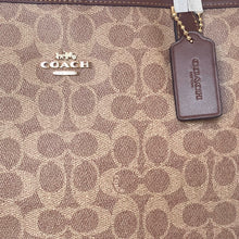 Load image into Gallery viewer, Coach bag with logo and tag on a patterned background