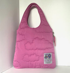 Pink quilted bag with a visible brand label on a white background