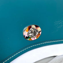Load image into Gallery viewer, Close-up of a colorful car door handle on a teal car.
