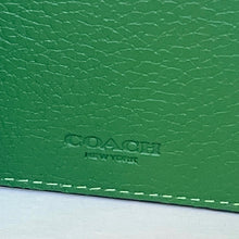 Load image into Gallery viewer, Close-up of a green Coach wallet with visible branding.