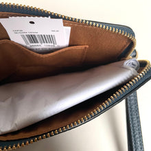 Load image into Gallery viewer, Open leather wallet with a visible brand label on a white background