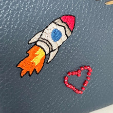 Load image into Gallery viewer, Embroidered rocket and heart on a textured surface
