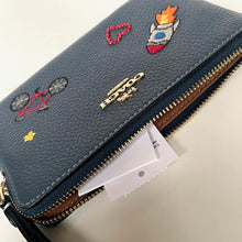 Load image into Gallery viewer, Blue wallet with colorful embroidered designs on a beige background
