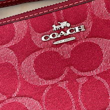 Load image into Gallery viewer, Close-up of a pink handbag with a visible Coach logo.