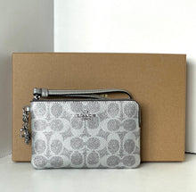 Load image into Gallery viewer, Silver patterned Coach wallet with keychain on a beige box