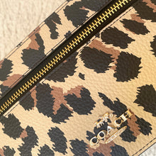 Load image into Gallery viewer, Leopard print pouch with gold zipper and decorative charm on a beige background