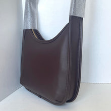 Load image into Gallery viewer, Brown leather handbag on a white surface with a light gray curtain background