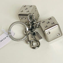 Load image into Gallery viewer, Silver dice-shaped keychain with a tag on a white background