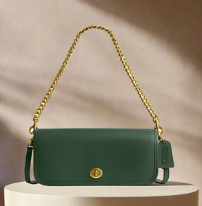 Green handbag with gold chain strap on a light gray background