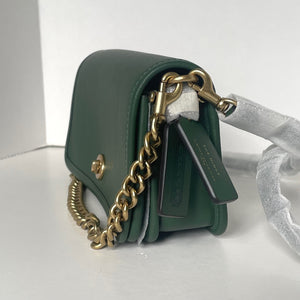 Green handbag with gold chain detail on a white background
