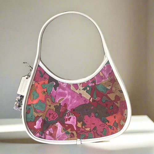 coach ergo leather Handbag with colorful abstract design on a neutral background