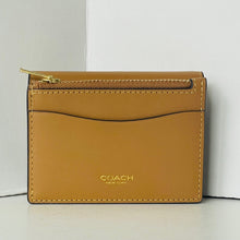 Load image into Gallery viewer, Tan leather wallet with gold zipper and 'Coach New York' logo on a white background