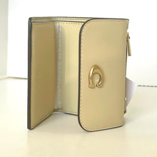 Load image into Gallery viewer, Beige wallet with gold horse shoe emblem on a white background
