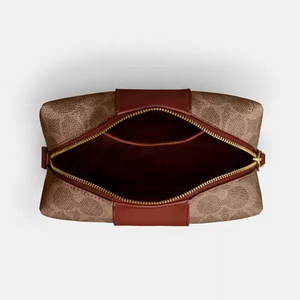 Brown leather pouch with gold zipper on a light gray background