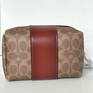 Coach handbag with brown leather stripe on a white background