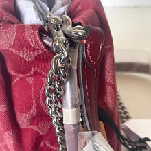 Load image into Gallery viewer, Close-up of a red handbag with a silver chain detail.